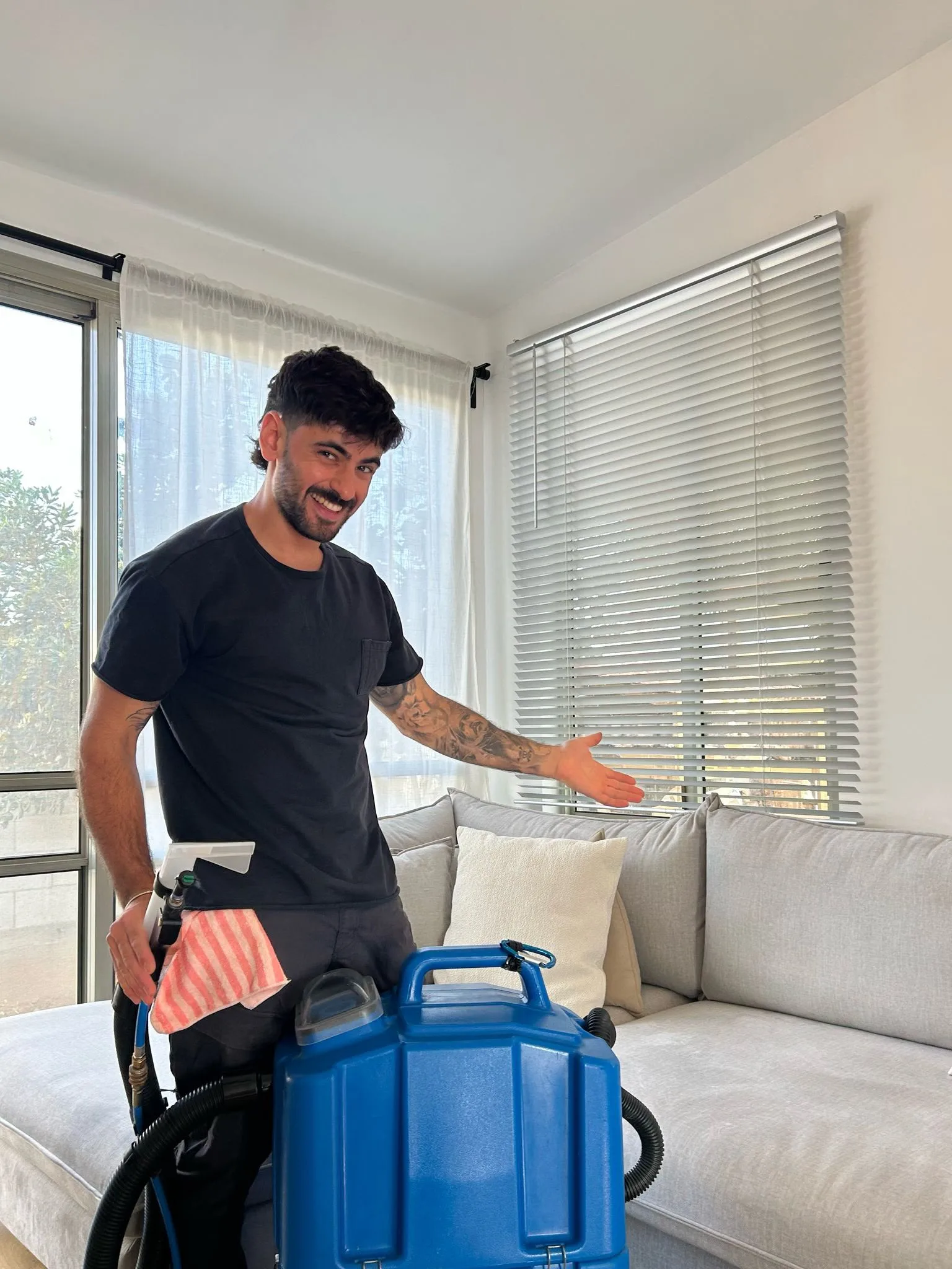 רותם פרנקל, בעלים של רותם ולירי פתרונות ניקיון, עם מכונת הזרקה ושאיבה בסלון לקוח