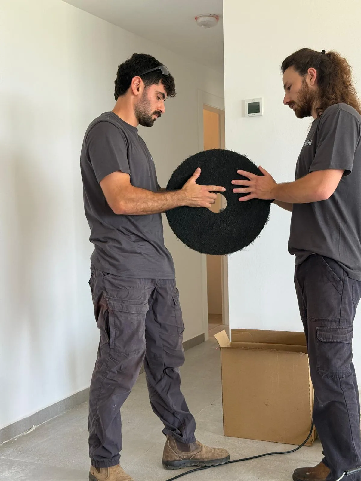 שני עובדי רותם ולירי מחליפים דיסקית פוליש בדירה